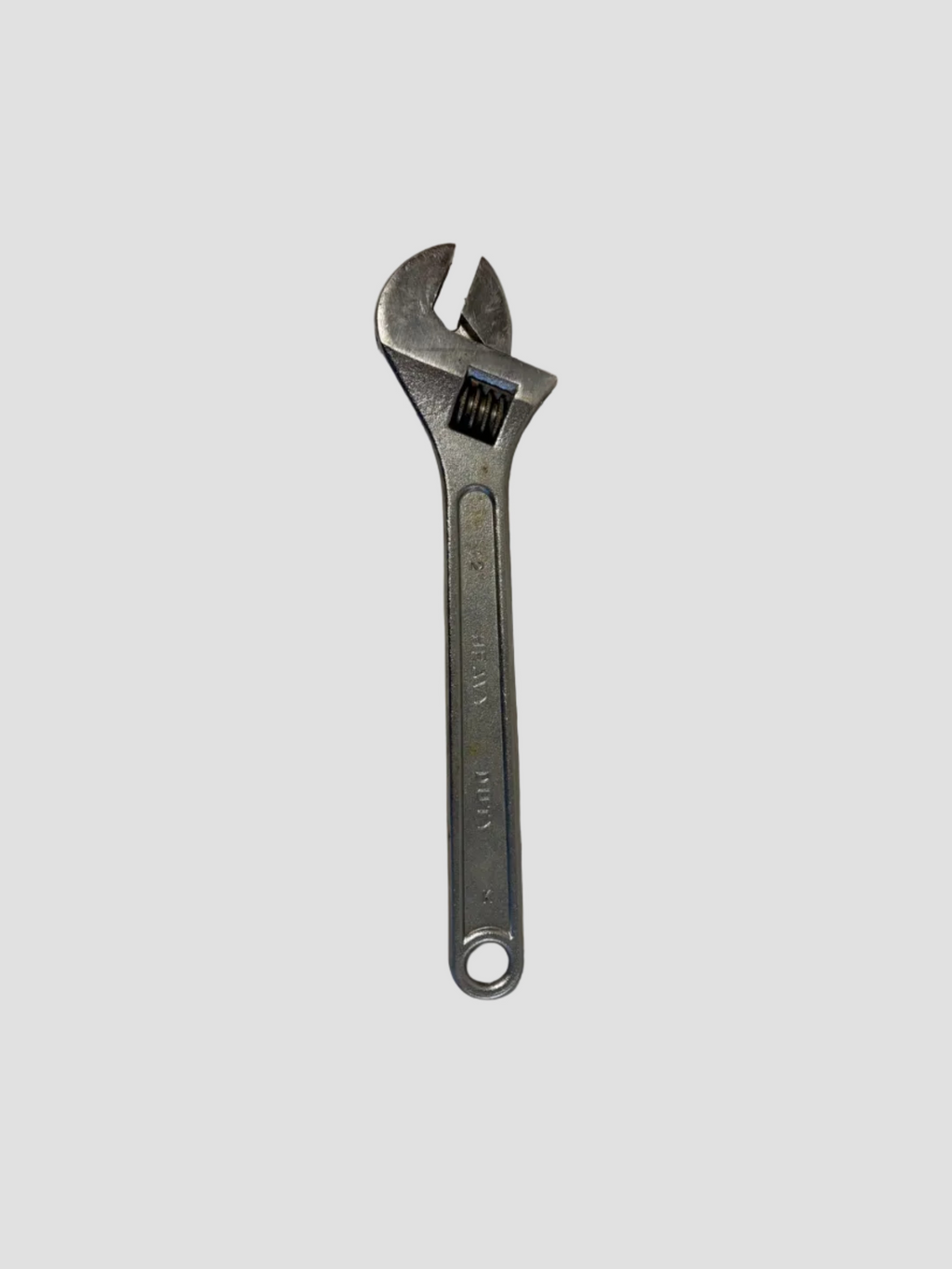 A silver adjustable wrench with a textured handle, shown on a plain off-white surface.