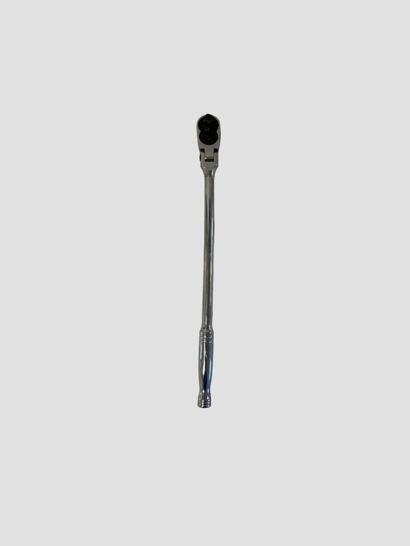A long chrome ratchet wrench placed on a light-colored surface. The tool has a polished metallic finish with a slightly curved handle and a rounded head featuring a black ratcheting mechanism and square drive socket connector. The lighting highlights the reflective surface and smooth contours of the wrench.
