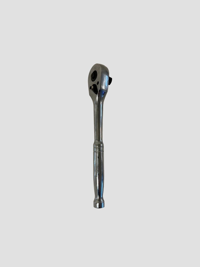 A chrome ratchet wrench with a textured handle, shown vertically against a solid light gray background.