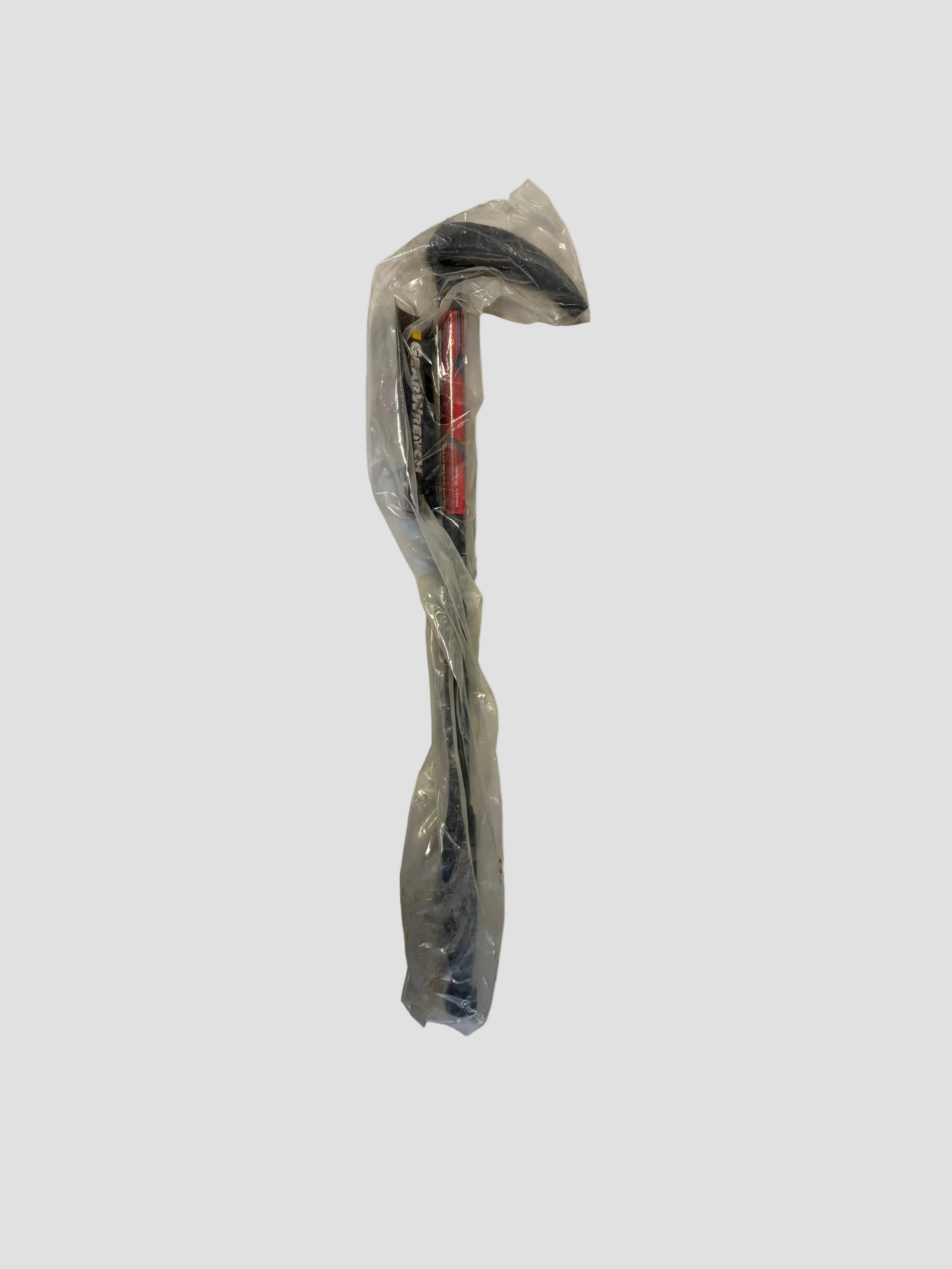 A claw hammer wrapped in a clear plastic bag, resting on a light-colored surface. The hammer has a black handle with a red section near the head, which features a metallic striking face and a curved claw for nail removal. The packaging suggests the hammer is new, and the visible label includes the brand name “Stanley FatMax.”