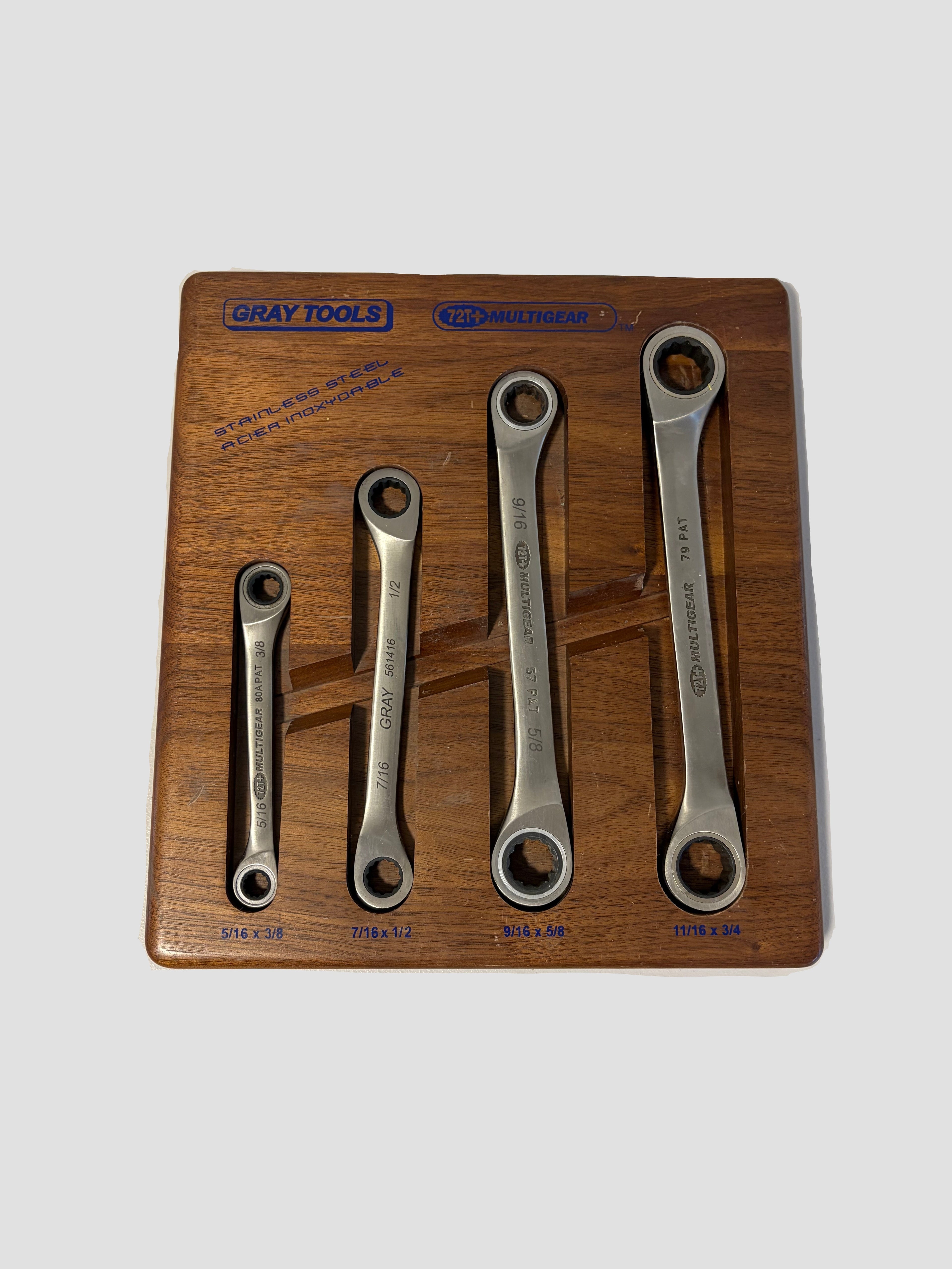 A set of five Gray Tools combination wrenches displayed in a wooden presentation tray on a light off-white background.