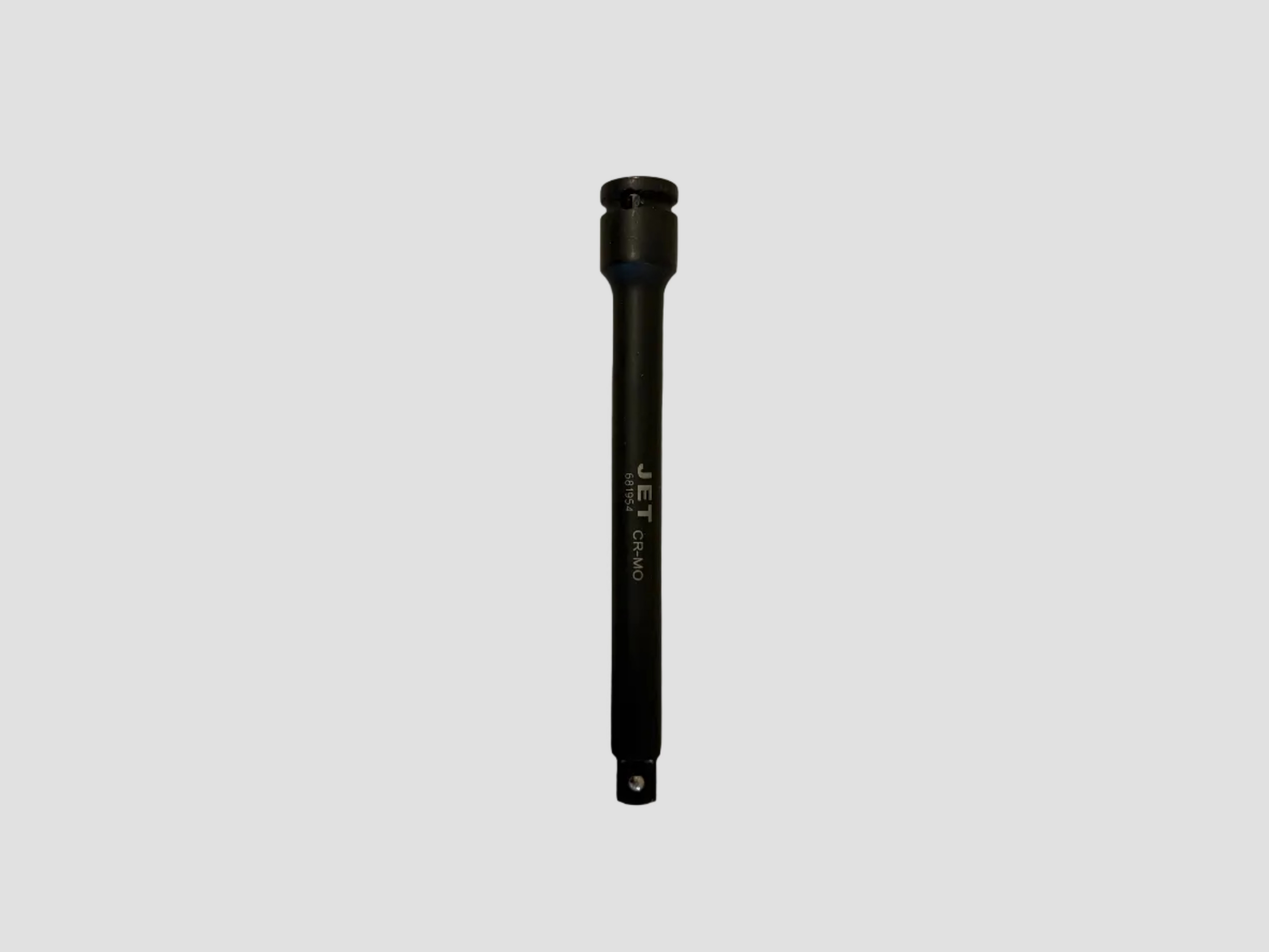 A black Jet Clean jet atomizer nozzle with white printed branding, lying vertically on a light-colored, slightly textured surface.