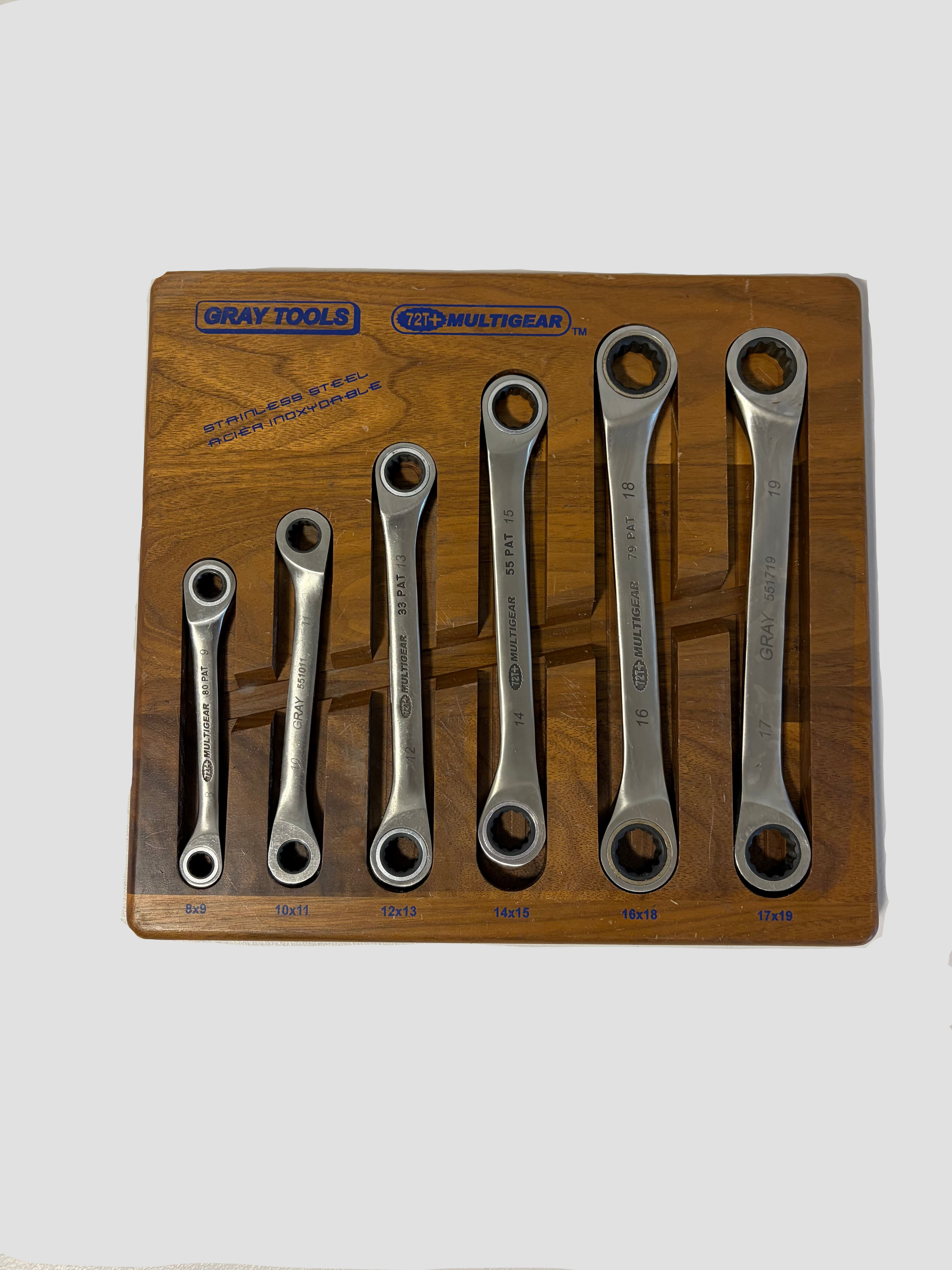 A set of seven Gray Tools 120MM Multiear combination wrenches in varying sizes, displayed on a wooden presentation board with the Gray Tools logo.