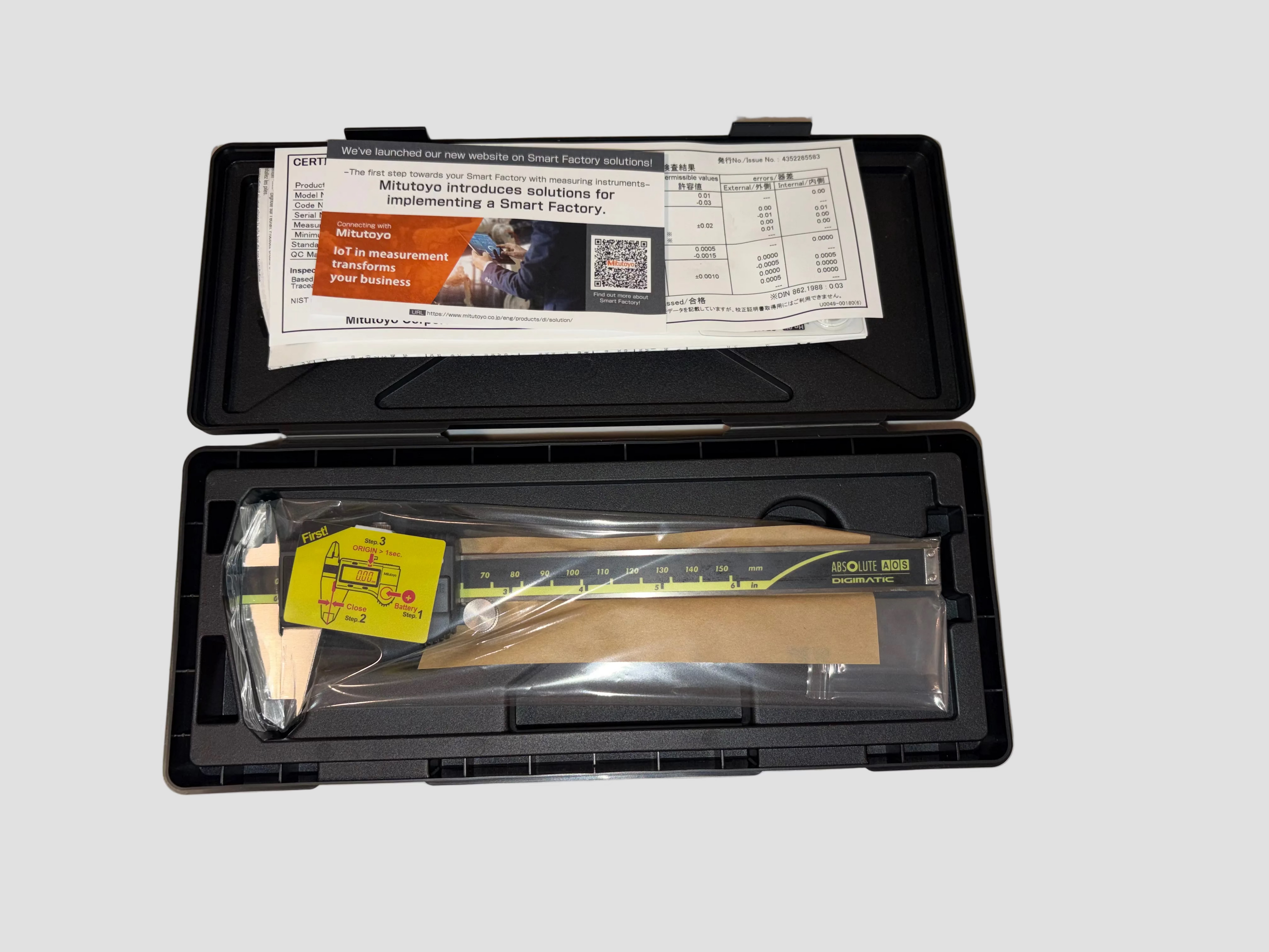 Open black case with tools and a ruler on a gray background