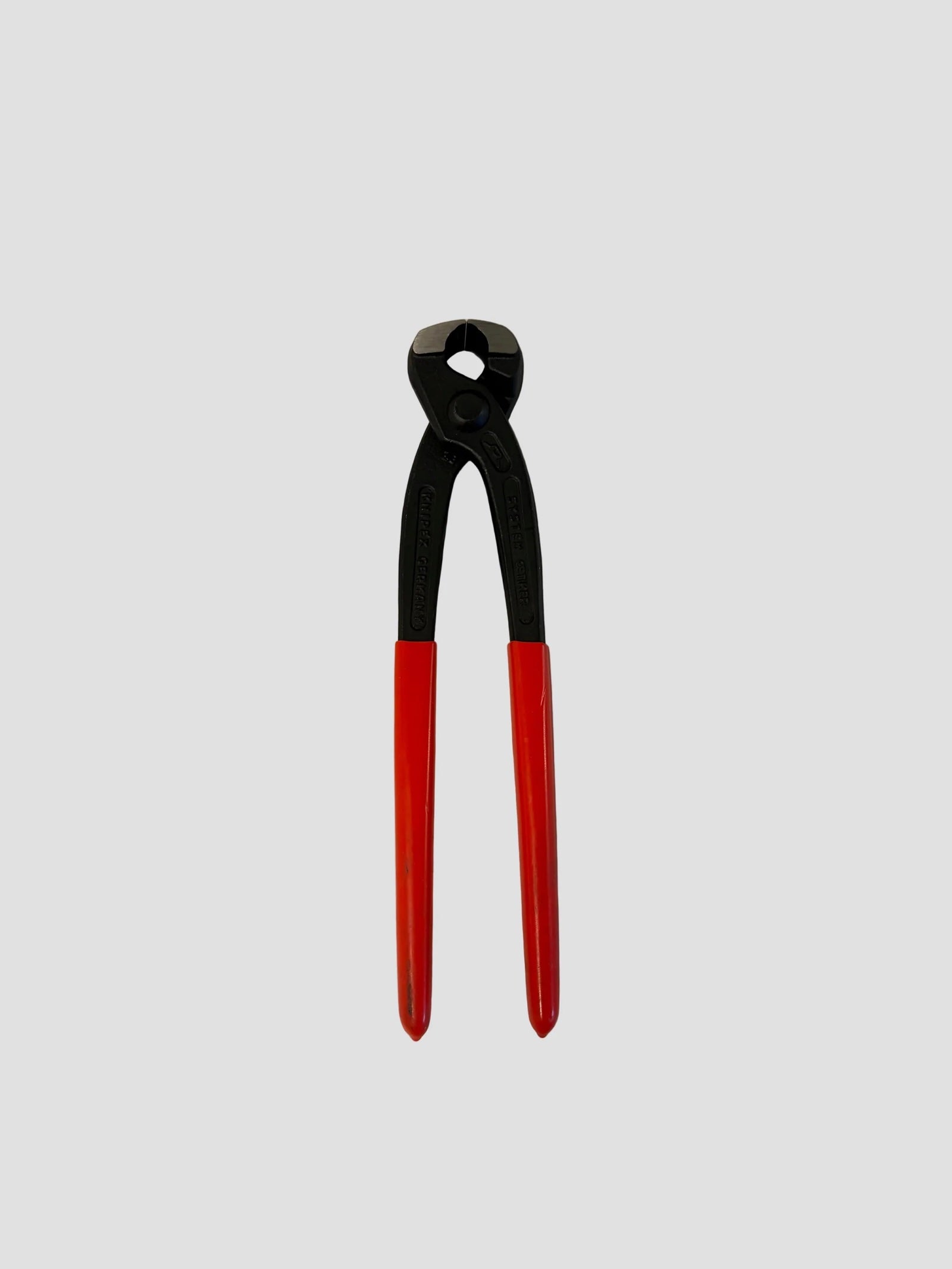 A pair of hand tools with black upper sections and red lower handles, centered on a light gray background.