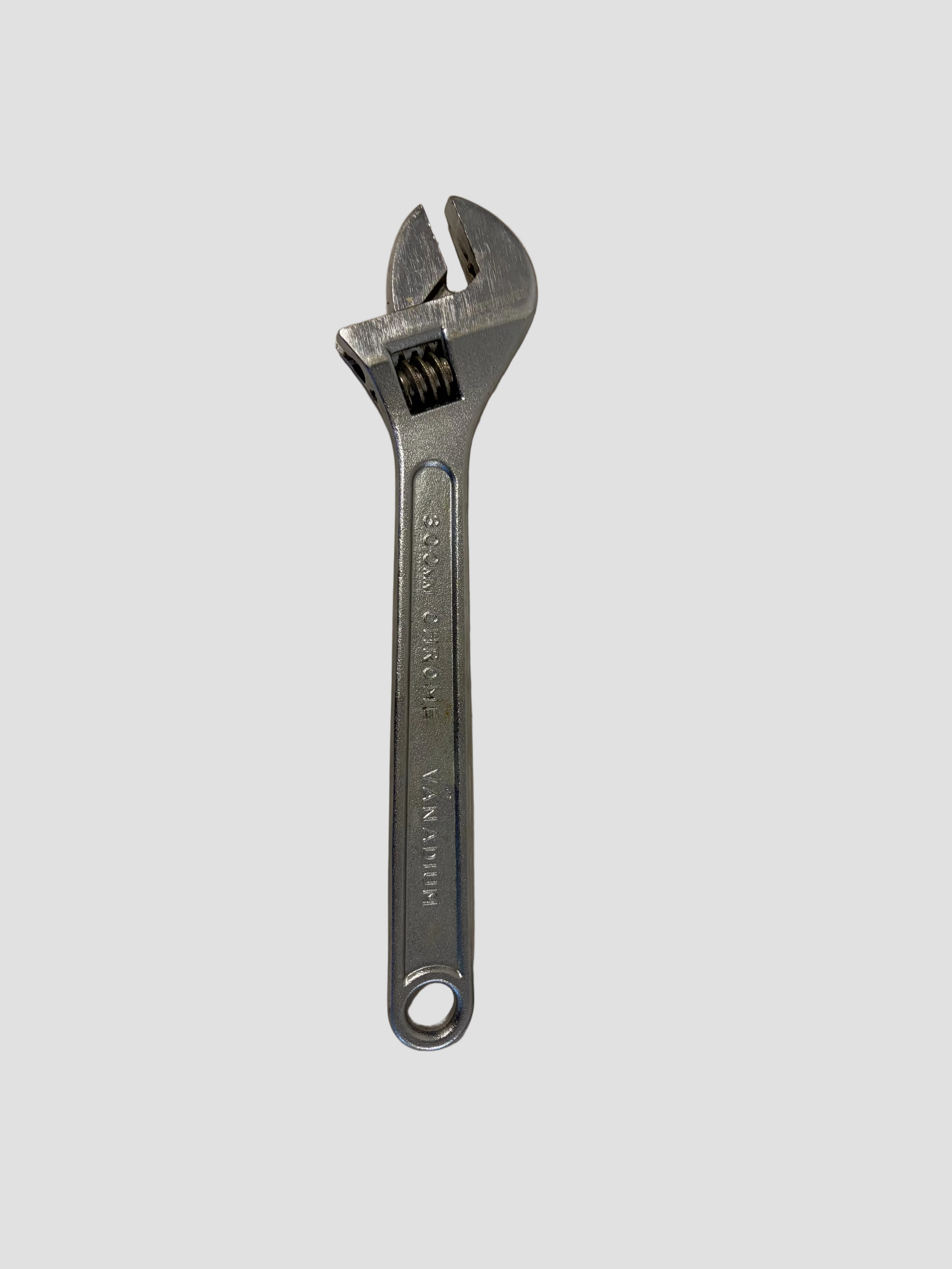 A silver adjustable wrench with a textured handle, photographed on a plain off-white surface.
