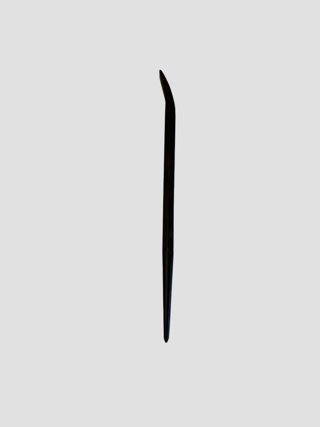 A small black pry bar resting on a light-colored surface. The tool has a straight shaft with a pointed end and a curved, flattened claw at the opposite end for prying or lifting. Its dark metal finish shows slight wear, indicating regular use. The compact design suggests it’s intended for precision tasks such as removing nails or separating small materials.