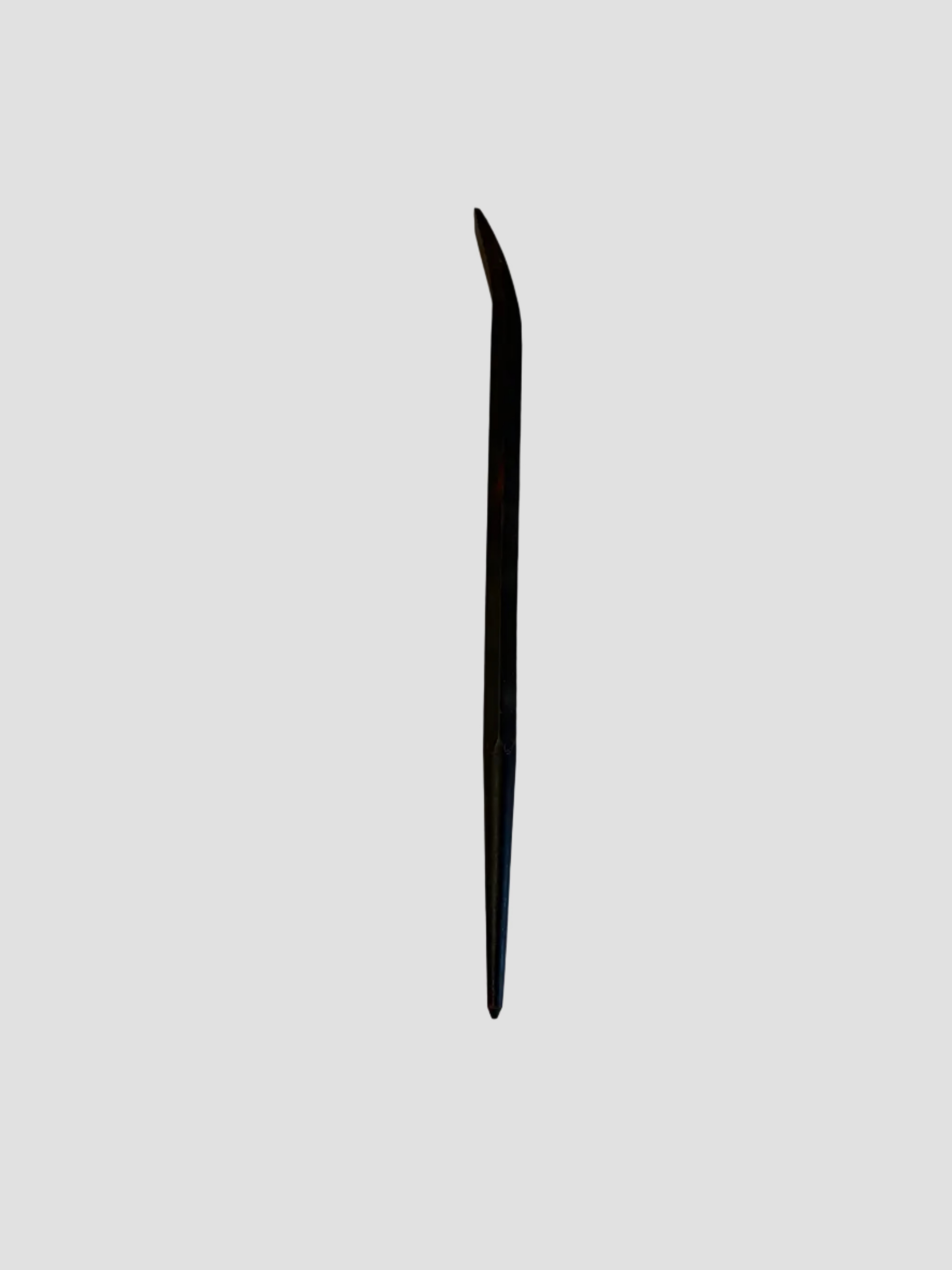 A small black pry bar resting on a light-colored surface. The tool has a straight shaft with a pointed end and a curved, flattened claw at the opposite end for prying or lifting. Its dark metal finish shows slight wear, indicating regular use. The compact design suggests it’s intended for precision tasks such as removing nails or separating small materials.