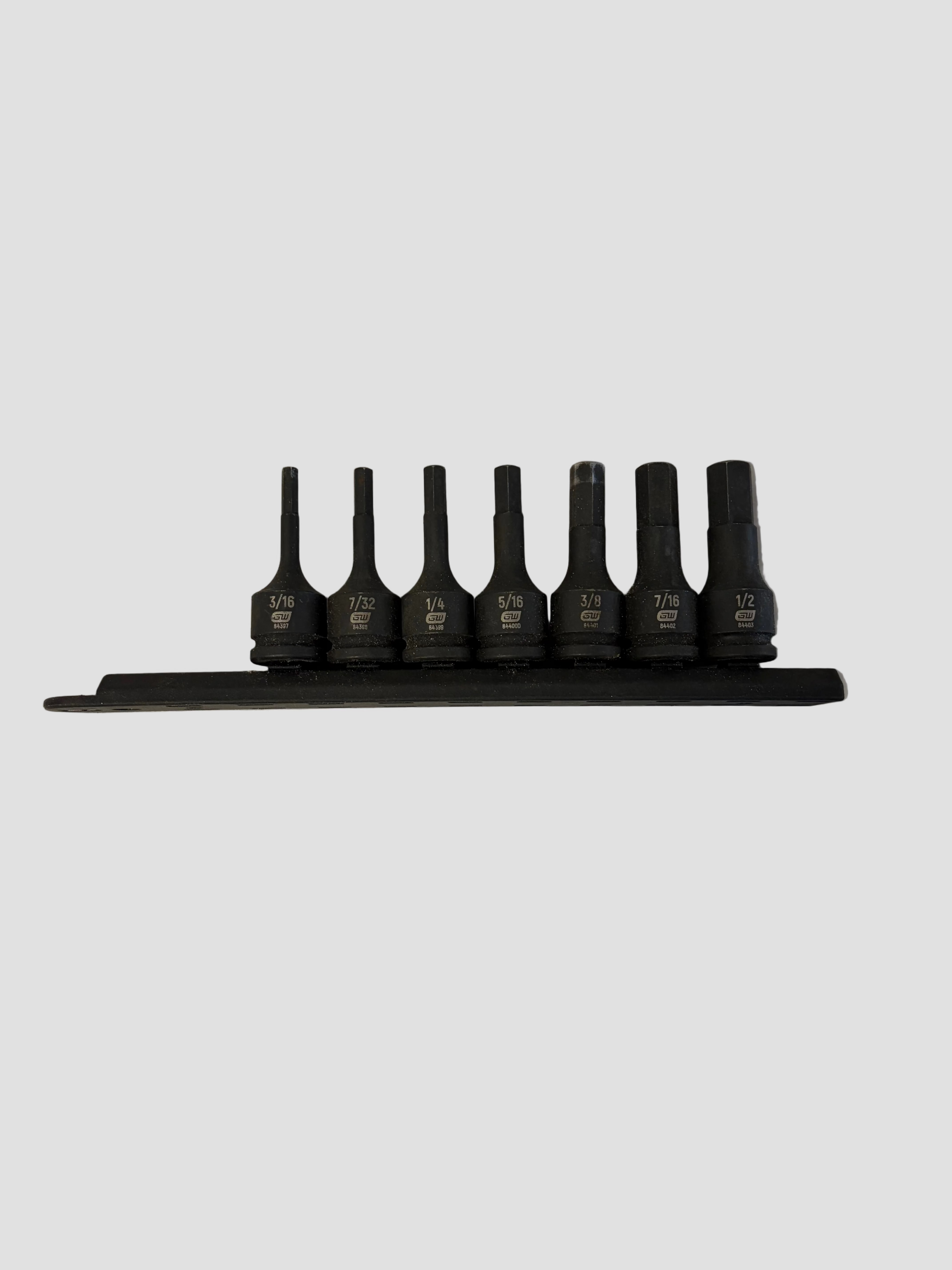 A set of seven black hex (Allen) socket bits arranged neatly in a holder on a light-colored surface. Each bit is labeled with its size, ranging from 3/16 to 1/2 inch, and marked “SNAP-ON USA.” The bits are organized in ascending order from left to right, showing their uniform cylindrical shape and matte finish, typical of precision hand tools used for mechanical work.