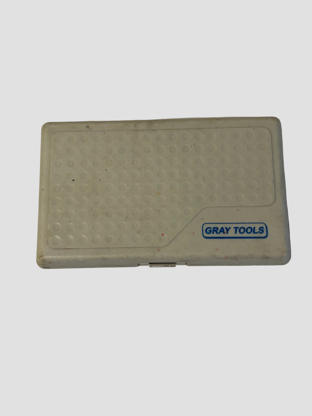 A gray plastic case with a textured honeycomb pattern and a blue 'GRAY TOOLS' logo, resting on a white surface.