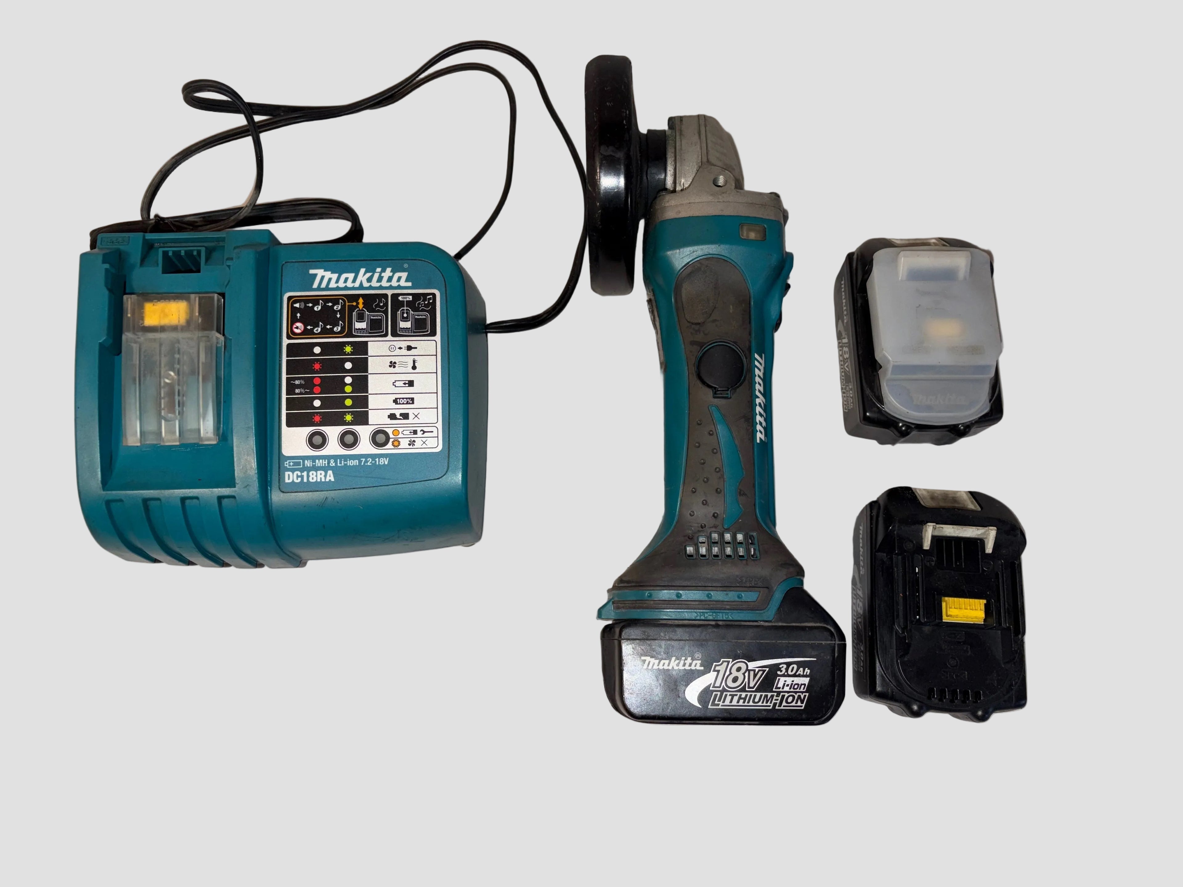 makita grinder with charger and 1 attached battery and 2 detached batteries