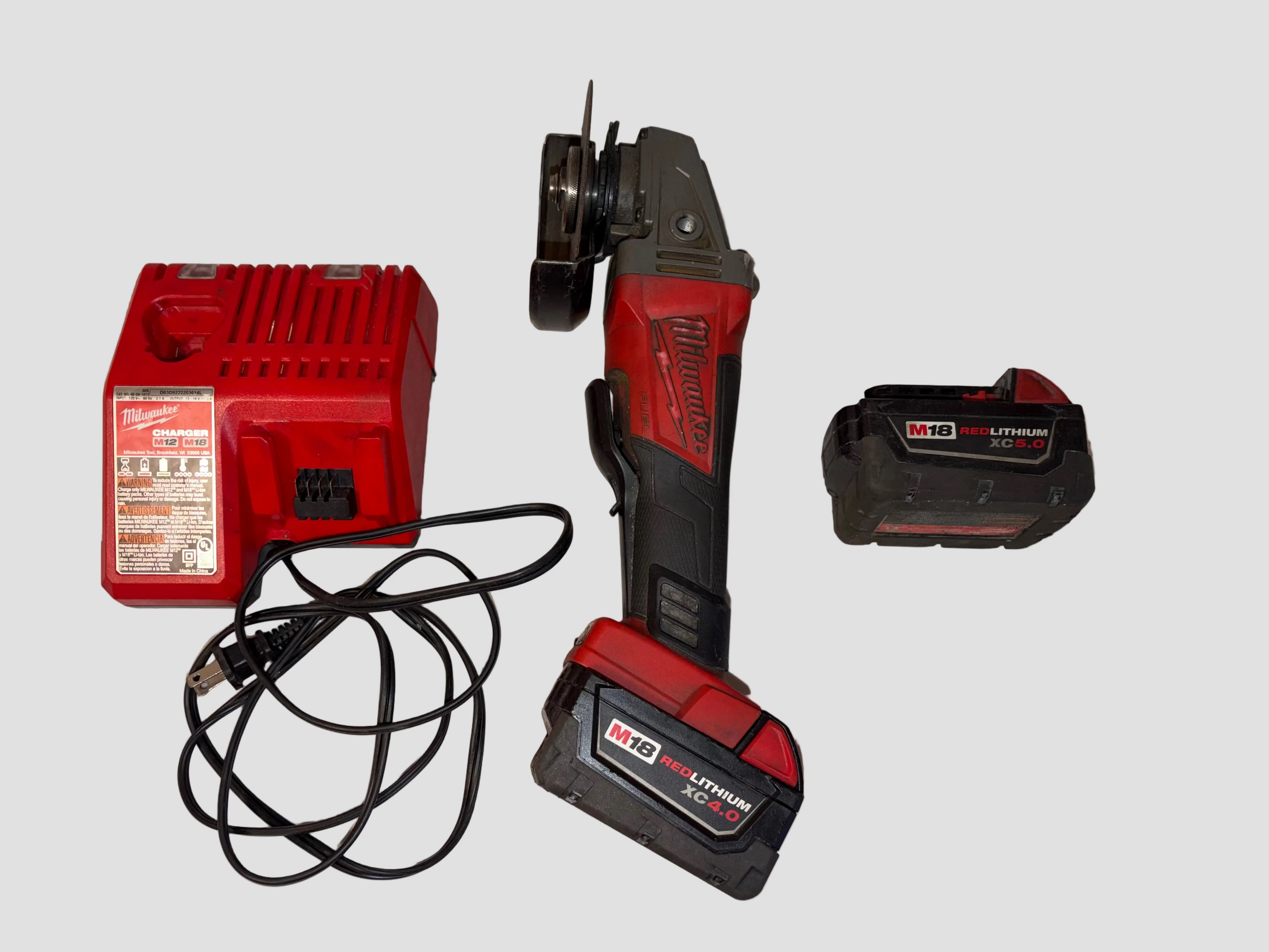 milwaukee grinder with charger 1 attached battery and 1 detached battery