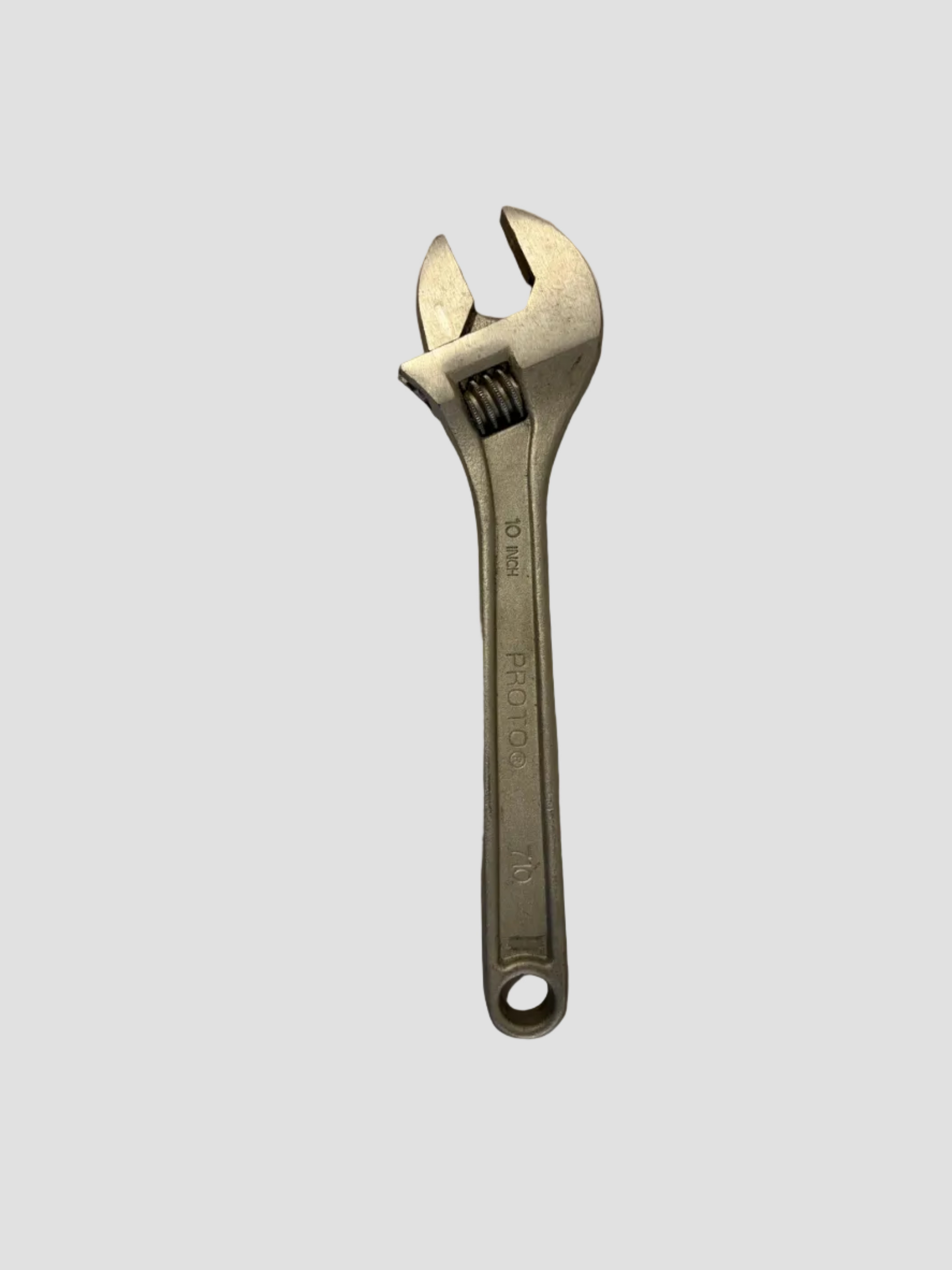A silver adjustable wrench with a textured handle and a spring-loaded locking mechanism, shown on a plain light gray surface.